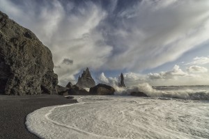 Large waves crash against the shoreline and sea stacks on the southern shore of Iceland, near Vik; Iceland