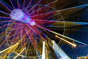 Colourful lights of a moving ferris wheel at nighttime; Calgary, Alberta, Canada