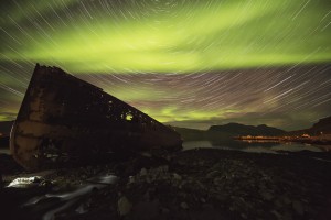 Star trails and northern lights over top the town of Djupavik in the West Fjords of Iceland; Djupavik, Iceland
