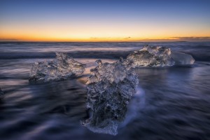 Waves break around icebergs on the southern shore of Iceland, near the glacial lagoon of Jokursarlon; Iceland