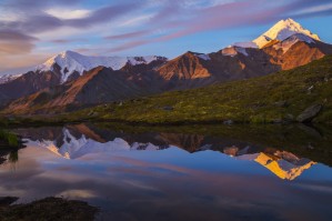 Mount Hayes reflects in a pond at sunrise, viewed from a remote area near the Hayes Glacier in the Alaska Range; Alaska, United States of America