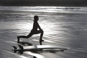 Surfer Stretching On Beach