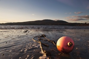 Dumfries, Scotland; A Rope Tied To A Buoy Laying In The Tide On The Shore