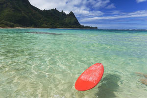 Hawaii, Kauai, Haena Beach Tunnels Beach, Red Surfboard Floating In Shallow Ocean.