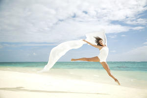 Hawaii, Oahu, Lanikai Beach, Beautiful Female Ballet Dancer Leaping Into Air On Beach With White Flowing Fabric.