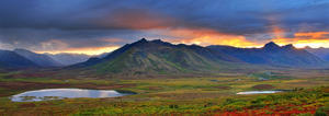 Shafts Of Sunlight Rising Above The Mountains And Fall Colours Of The Dempster Highway, Yukon