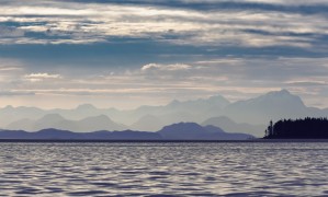 The Coastal Mountain Range Shrouded In A Morning Mist On The Coast; British Columbia, Canada