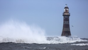 Splashing water from a crashing wave against a lighthouse;Sunderland Tyne and Wear England