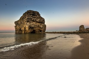 A large rock formation on the coast at sunset; South Shields, Tyne and Wear, England