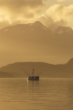 A commercial fishing vessel long line heads south in Lynn Canal near Juneau, Alaska, Chilkat Mountains beyond.