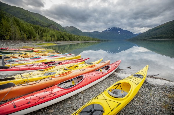 Kayaks in a row on shore at Eklutna Lake, Chugach Mountains, Southcentral Alaska. by PacificStock
