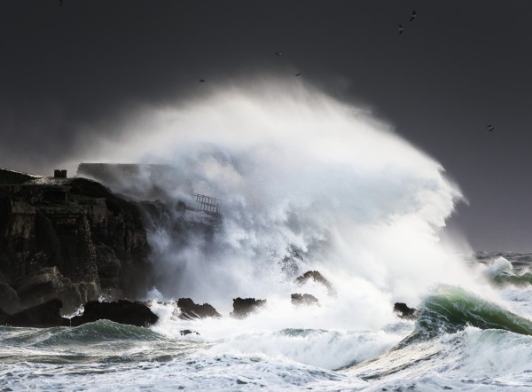 Wave crashing into shore and splashing onto the land above the cliffs, Isla de la Palomas; Tarifa, Cadiz, Andalusia, Spain by PacificStock