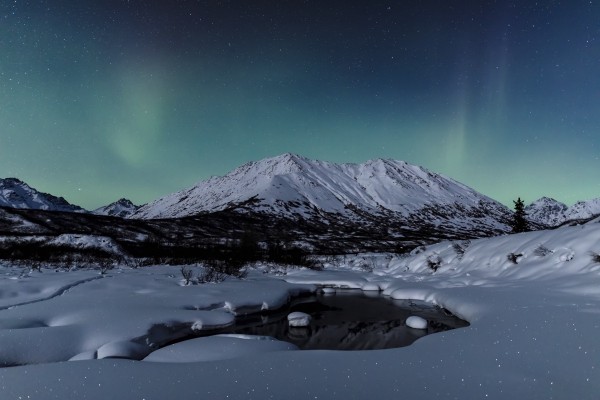 Aurora Borealis (Northern Lights) dance above Idaho Peak and the Little Susitna River at Hatcher Pass in winter, South-central Alaska; Alaska, United States of America  Print