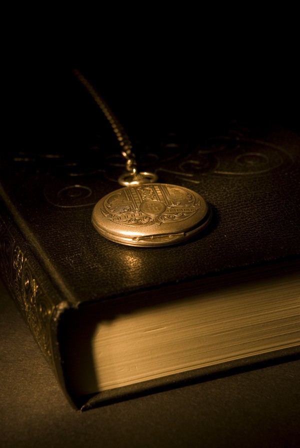 Gold Pocket Watch Resting On A Book by PacificStock