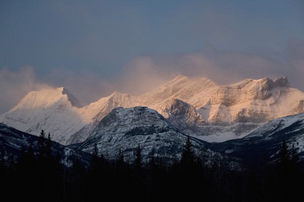 Alberta, Canada; Fog Around The Snow Covered Mountain Range At Sunrise In Kananaskis Country by PacificStock