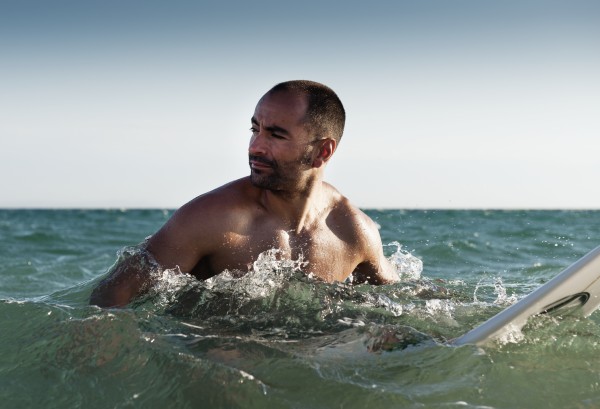 A Man With His Surfboard In The Water; Tarifa, Cadiz, Andalusia, Spain by PacificStock