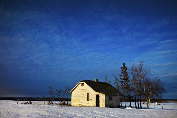 An Abandoned Homestead On A Snow Covered Field; Alberta, Canada by PacificStock