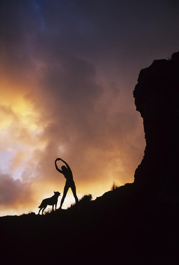 Hawaii, Silhouette Of A Woman Stretching On A Mountain Top At Sunset. by PacificStock