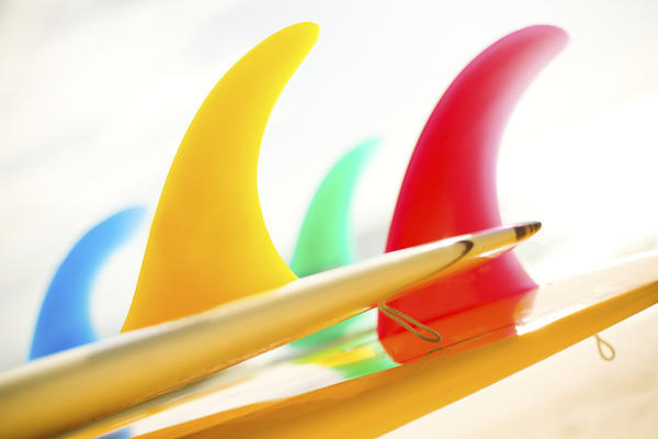 Colorful Surfboards Fins, Bright Sunny Sky In Background. by PacificStock