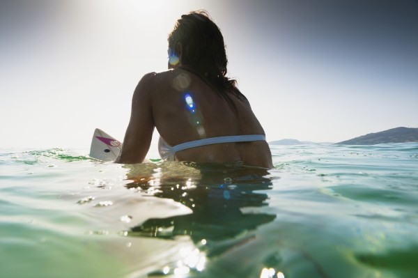A Woman Sitting On A Surfboard In The Water; Tarifa, Cadiz, Andalusia, Spain by PacificStock