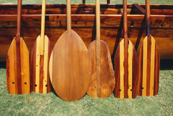 Hawaii, Different Shaped Canoe Paddles In Front Of Koa Canoe by PacificStock