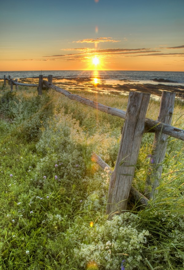 Sunset Over Water And A Fence Along The Shoreline; La Martre, Quebec, Canada by PacificStock