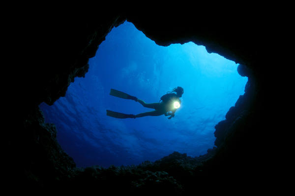 Hawaii, Big Island, Kona, Diver At Cavern Entrance With Flash Light, Silhouette A81E by PacificStock