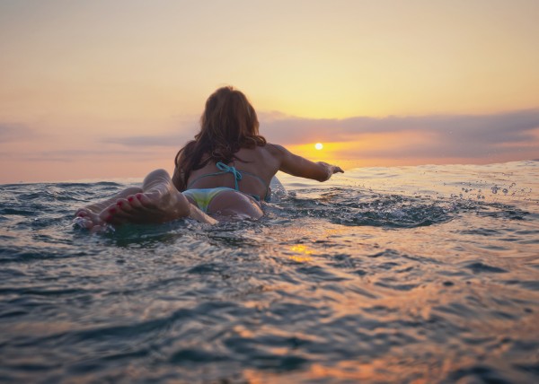 A Woman Laying On A Surfboard Watching The Sunset; Tarifa, Cadiz, Andalusia, Spain by PacificStock