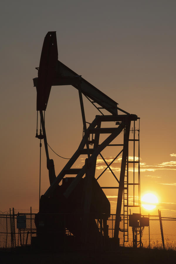 Silhouette Of Pumpjack With The Orange Glow Of The Sun Rising; Longview,Alberta, Canada by PacificStock