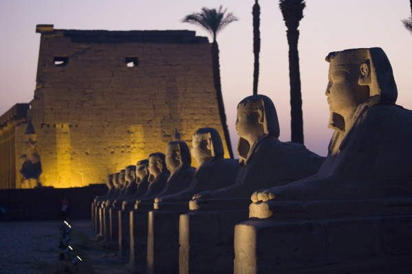 Stone Statues And The Luxor Temple On The East Bank Of Luxor Along The Nile River; Luxor, Egypt by PacificStock