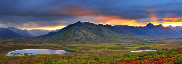 Shafts Of Sunlight Rising Above The Mountains And Fall Colours Of The Dempster Highway, Yukon by PacificStock