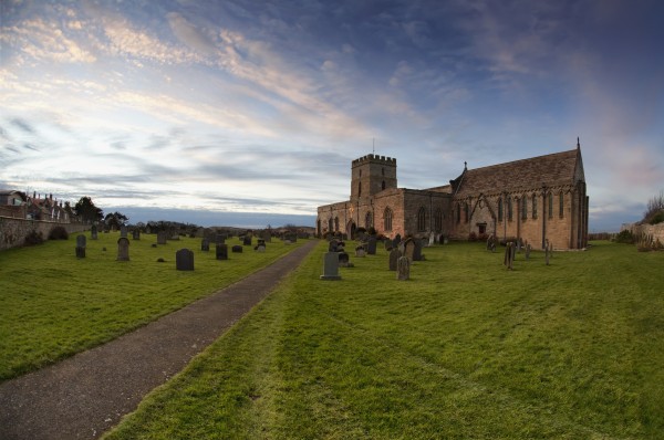 Path Leading To A Church Building And Cemetery; Bamburgh, Northumberland, England by PacificStock