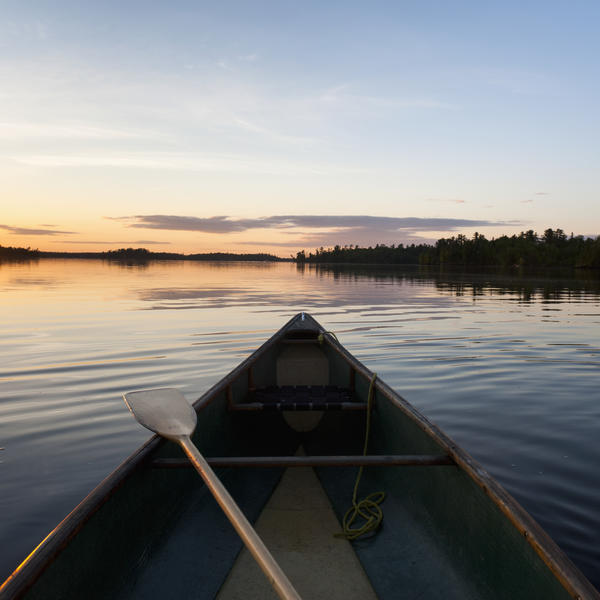 A Boat And Paddle On A Tranquil Lake At Sunset; Lake Of The Woods, Ontario, Canada by PacificStock