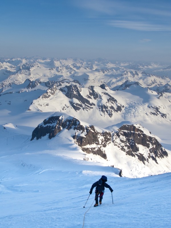 Climber Leaning Into High Winds On Northwest Ridge Of Mount Iliamna Above Tongue Glacier And Chigmit Mountains, Spring, Southcentral Alaska by PacificStock