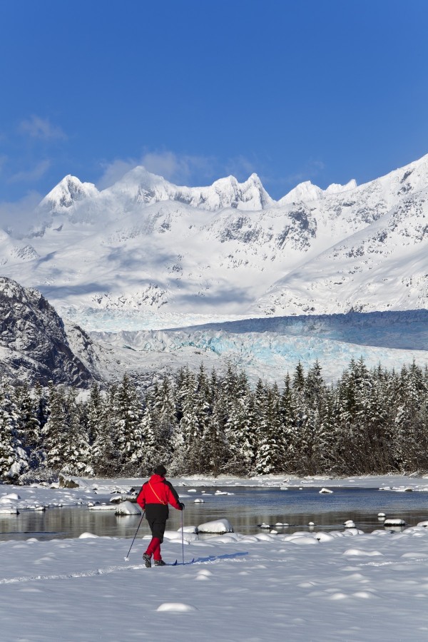 Person Cross-Country Skiing In A Winter Landscape At Mendenhall River With Mendenhall Glacier And Towers In The Background, Tongass National Forest, Southeast Alaska by PacificStock