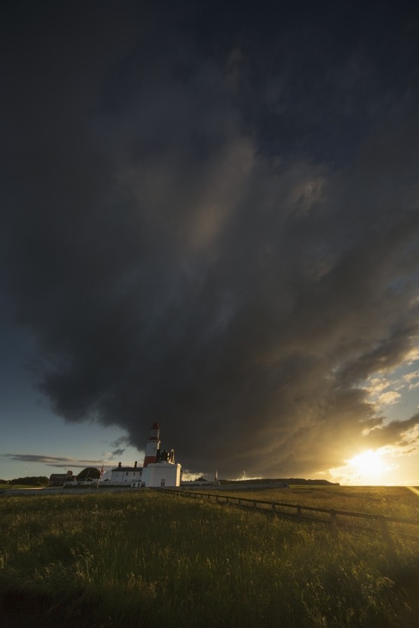 Storm cloud formation over a lighthouse at sunset;South shields tyne and wear england by PacificStock