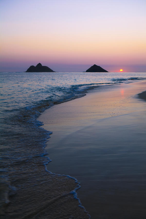 Hawaii, Oahu, Kailua, Lanikai, Sun sinking below horizon on beach. by PacificStock