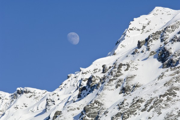 Moon Rising Over Snow Covered Mountain Peak At Hatcher Pass In Southcentral Alaska by PacificStock