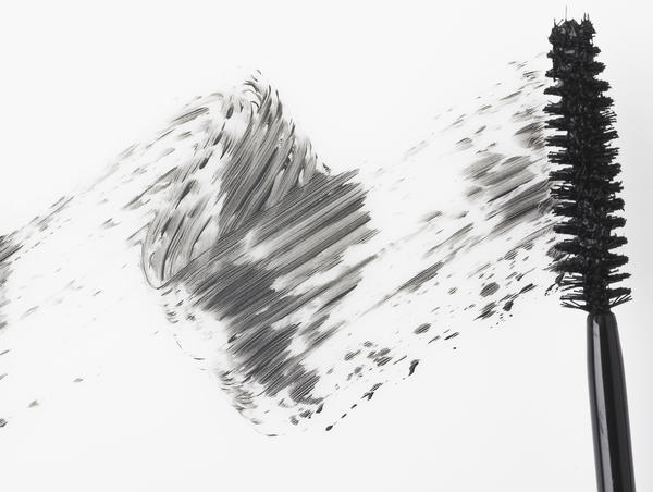 Mascara brush leaving traces of mascara on a white background by PacificStock