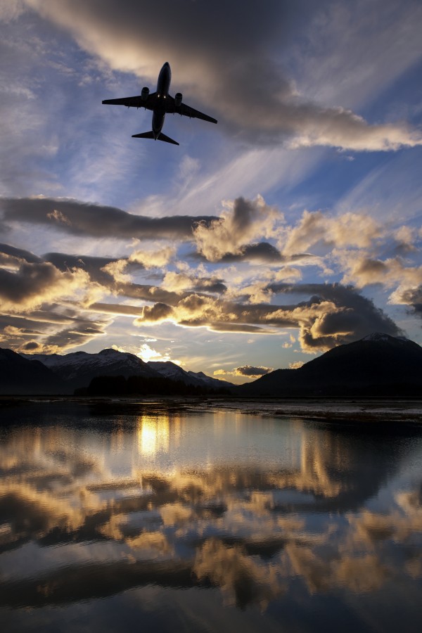 Alaska Airlines jet takes off from Juneau International airport at dawn, Juneau, Alaska. by PacificStock