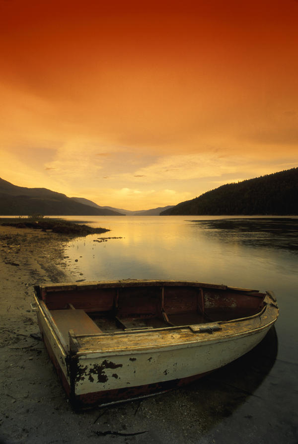 Old Rowboat At Water's Edge With Sunset Background by PacificStock