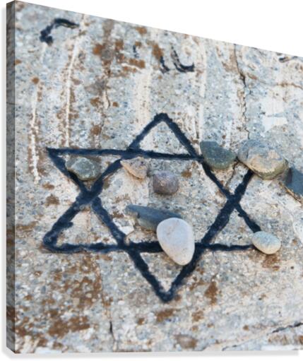 A star of david etched and painted on a rock with stones laying on it Canvas Print