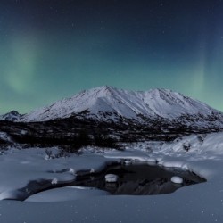 Aurora Borealis (Northern Lights) dance above Idaho Peak and the Little Susitna River at Hatcher Pass in winter, South-central Alaska; Alaska, United States of America