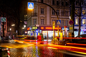 Long exposure night shot of a colourfully illuminated street corner and zebra crossing in Hamburg Altona