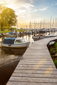 Boats at the pier of Langballigau during beautiful sunset at the Baltic Sea in Northern Germany