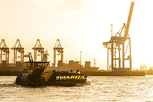 Ferry on the Elbe River in the harbor district in Hamburg during golden sunset 