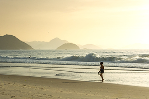 Woman strolling along Copacabana Beach in Rio de Janeiro in Brazil at sunrise 