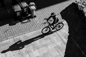 Black and white capture of a person riding a bike in the city  