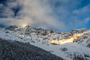 Sun ray shining through the clouds on a beautiful morning at the Ortler Mountain in South Tyrol 