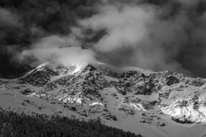 Black and white scene of clouds and sun rays at the wintry Ortler Mountain in South Tyrol 